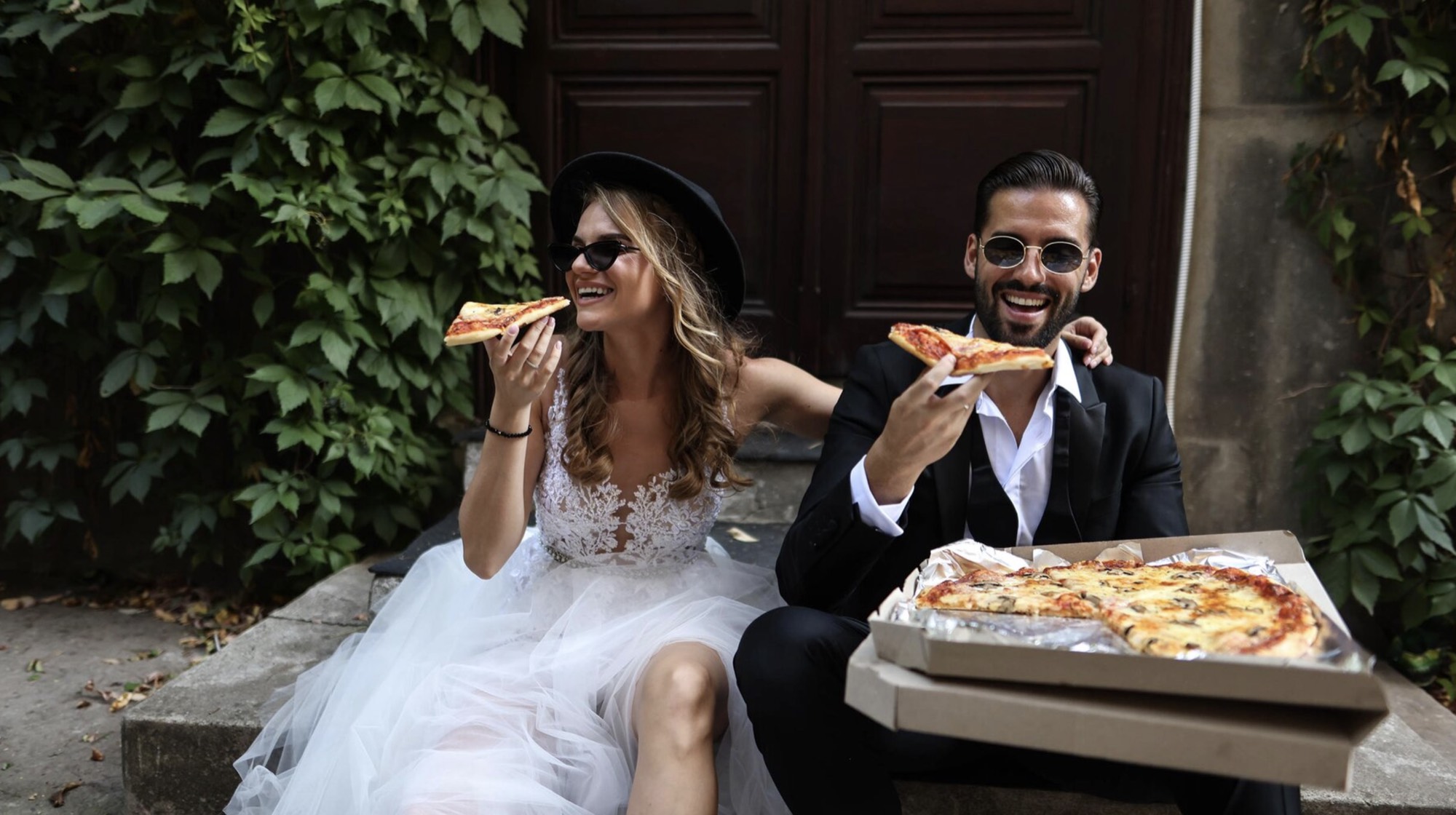 Newlyweds sharing pizza on the courtyard steps